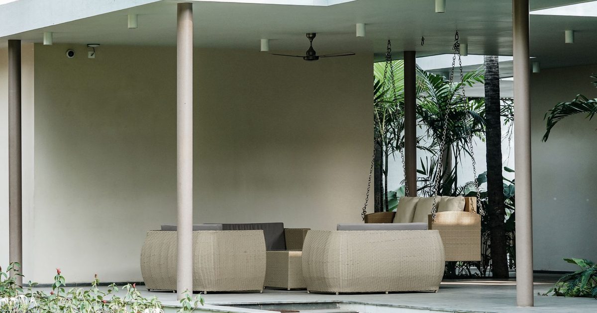 Spacious outdoor patio with modern wicker furniture, perfect for relaxing summer afternoons.